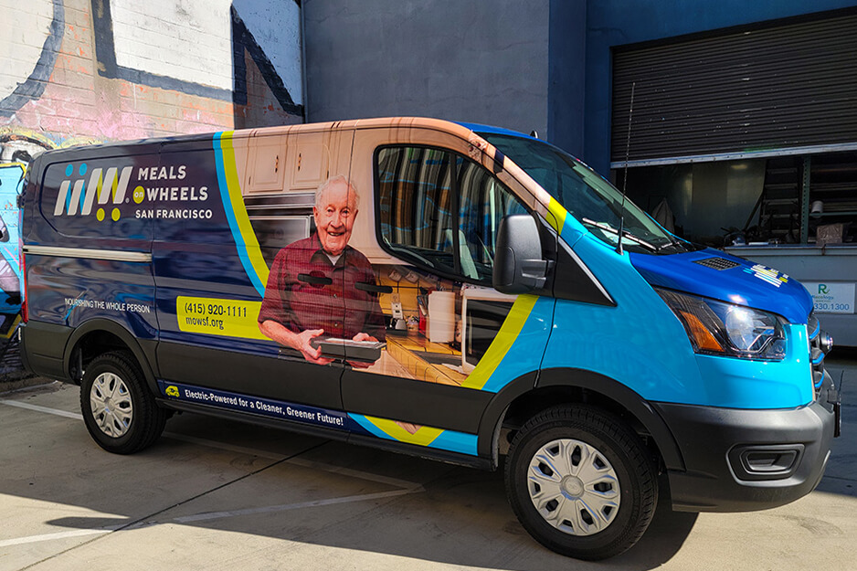 Xe van Meals on Wheels với đồ họa đầy màu sắc có khách hàng nam lớn tuổi