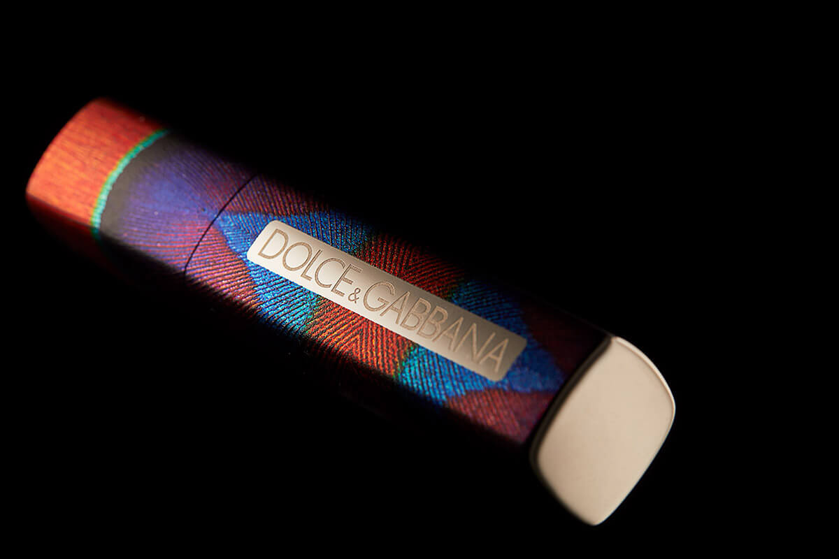 Multi-color lipstick container with the words Dolce and Gabbana in gold